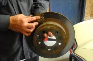 brake pads being shown by a mechanic