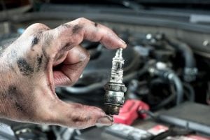 a sparkplug over being hold by a mechanic